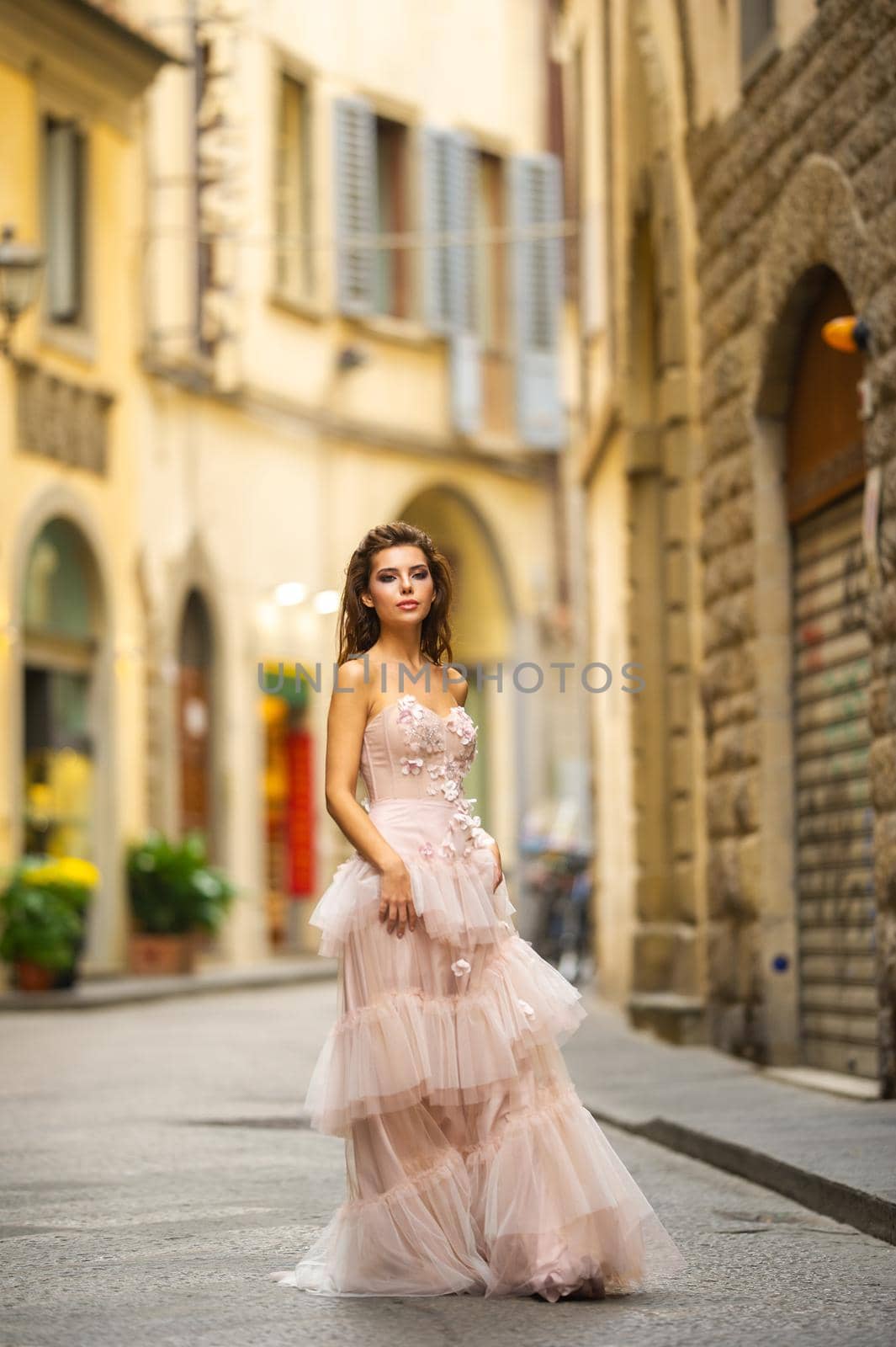 A bride in a pink wedding dress walks in Florence, Italy.