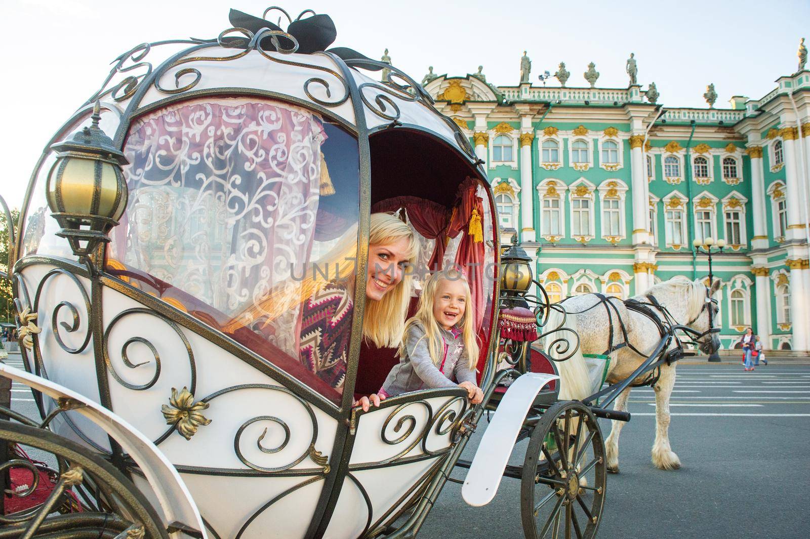 A girl with a child in an old carriage on Palace Square in St. Petersburg by Lobachad