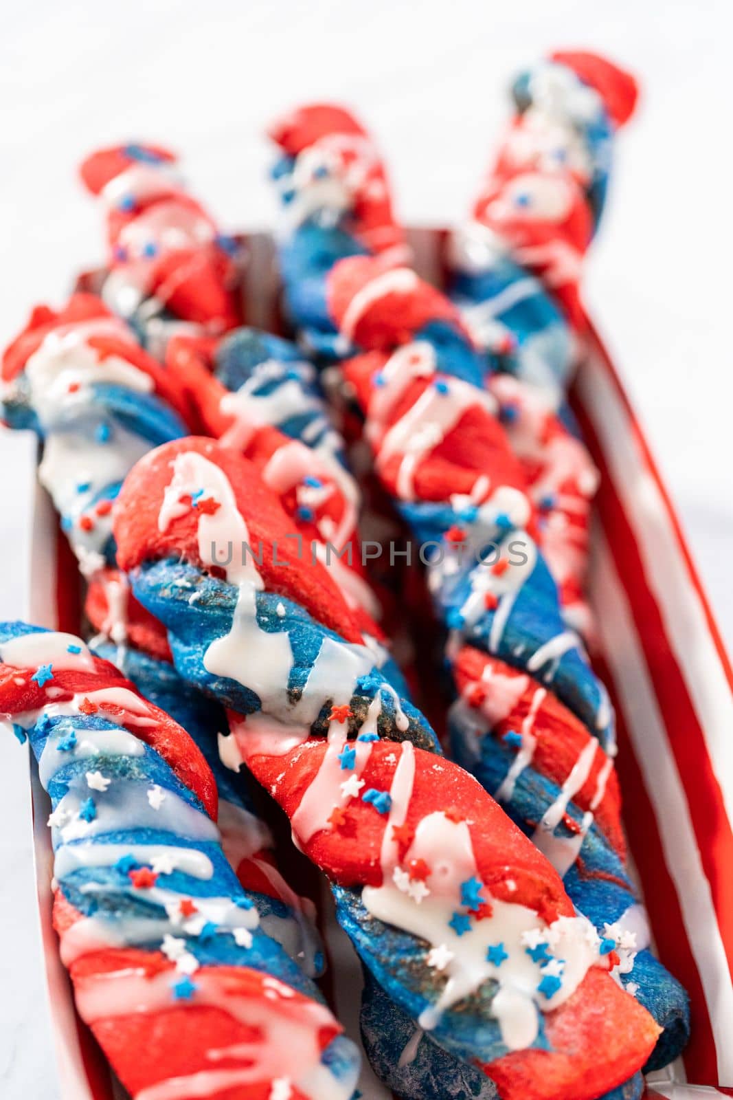 Patriotic cinnamon twists drizzled with a white glaze and decorated with star sprinkles.