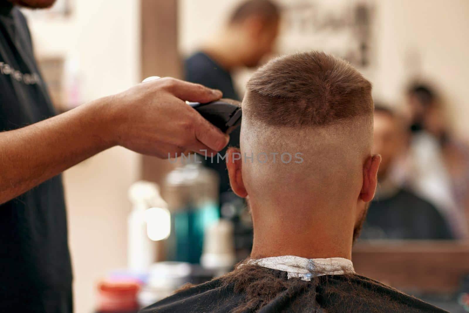 Barber shaving caucasian man in barber shop by erstudio