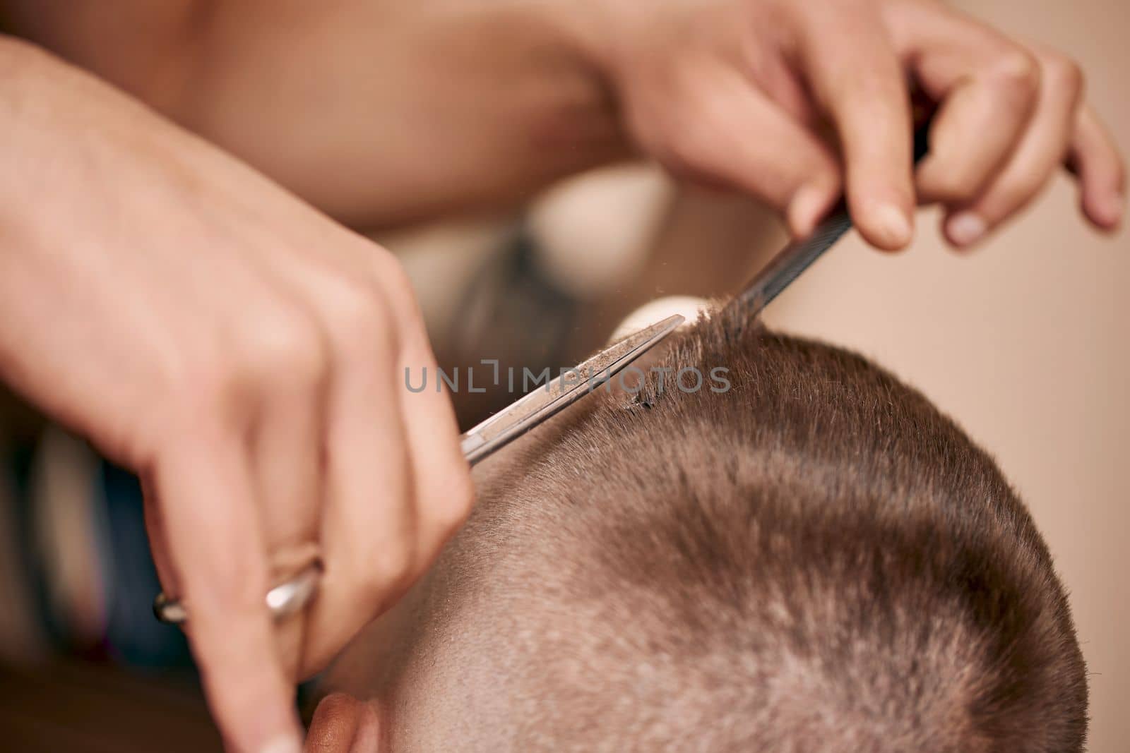 master hairdresser does hairstyle with scissors and comb. close-up