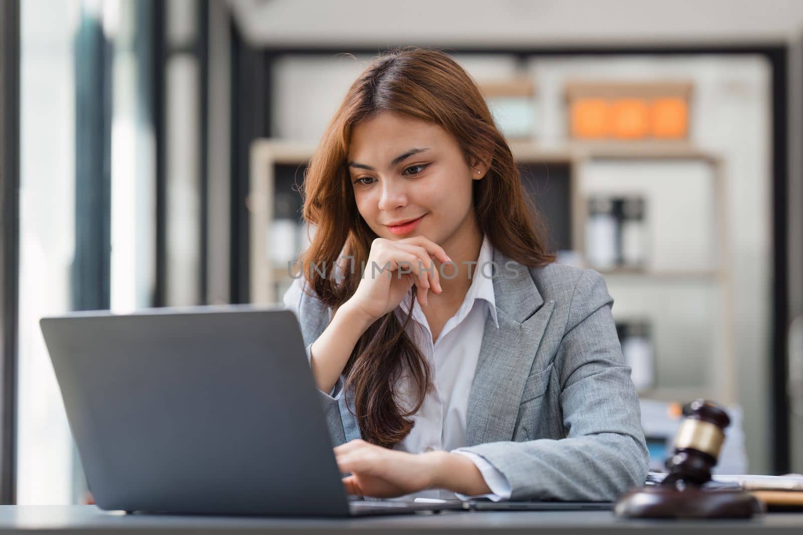 Business Lawyer consulting online on laptop while working at office