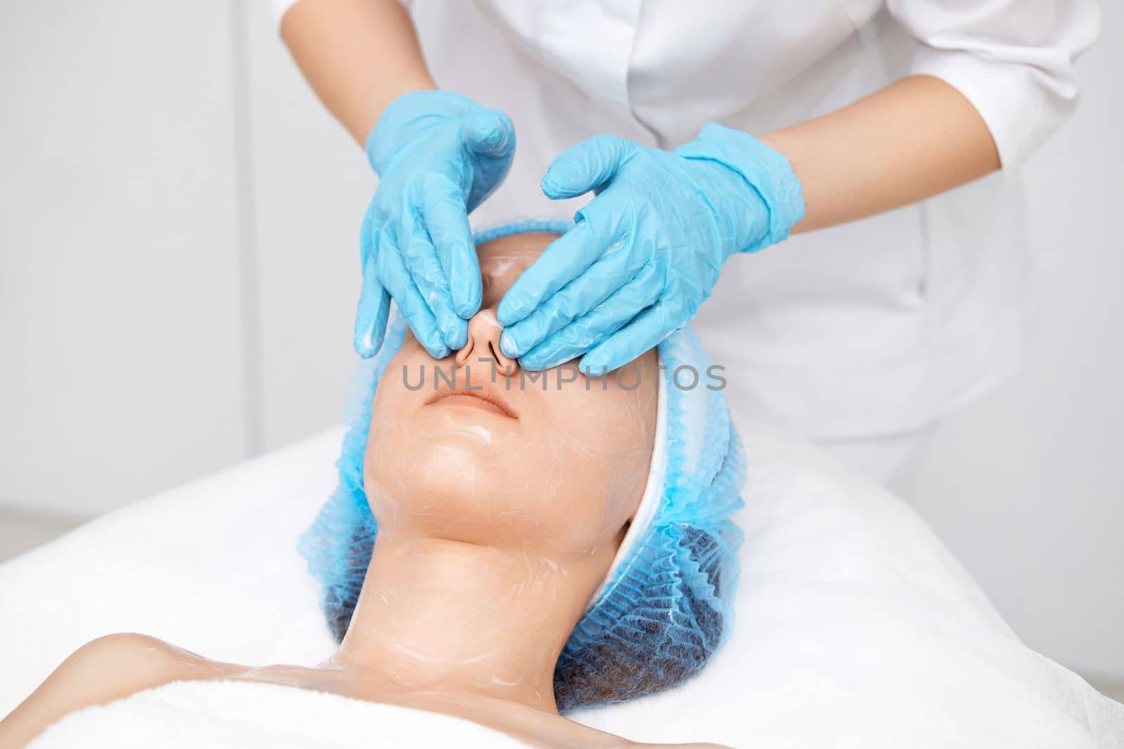 young beautiful woman receiving facial massage at spa salon