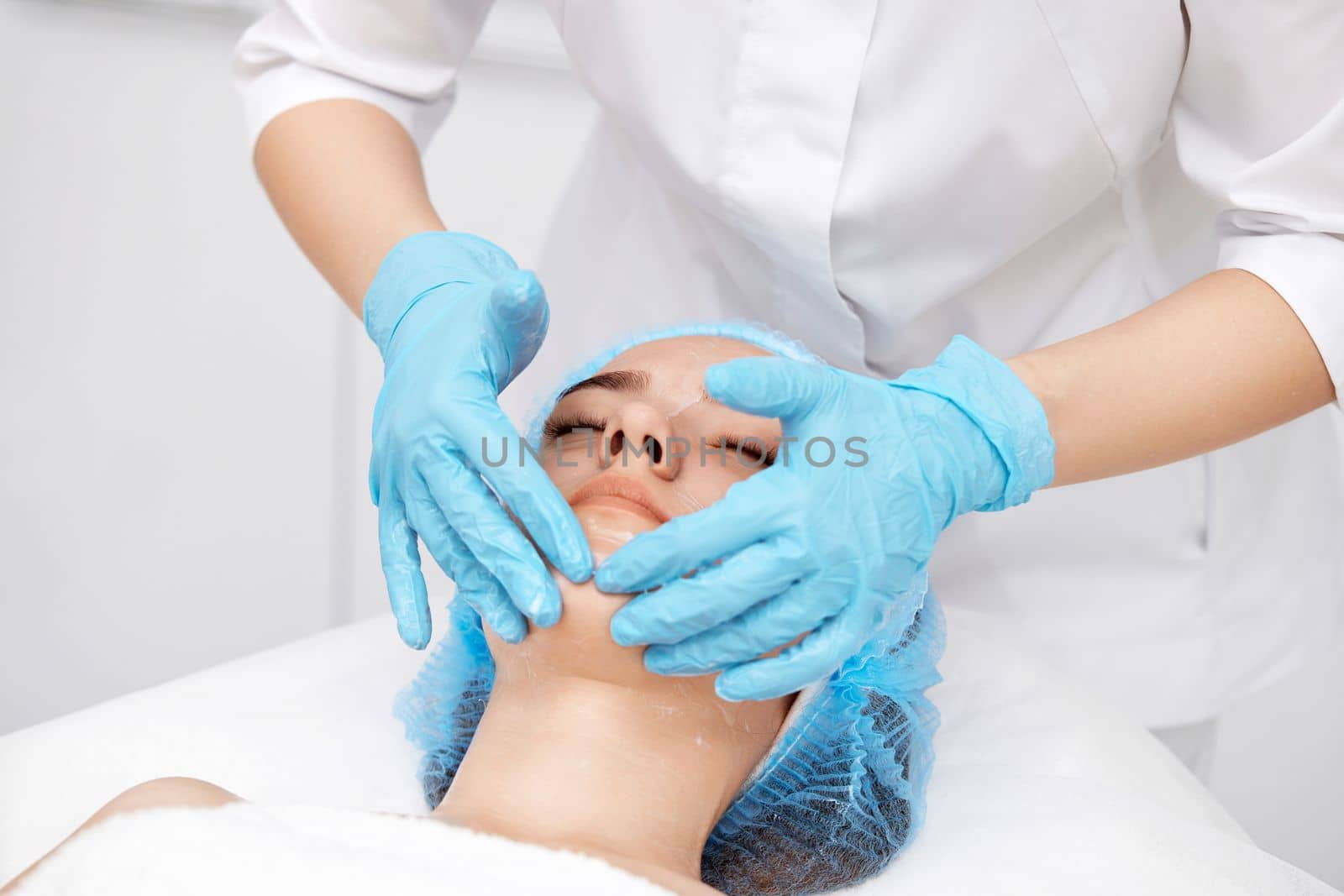 young beautiful woman receiving facial massage at spa salon
