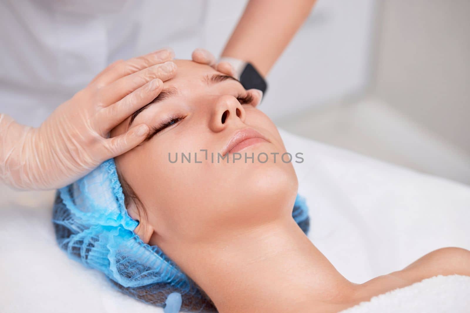 young beautiful woman receiving anti-stress facial massage at spa salon