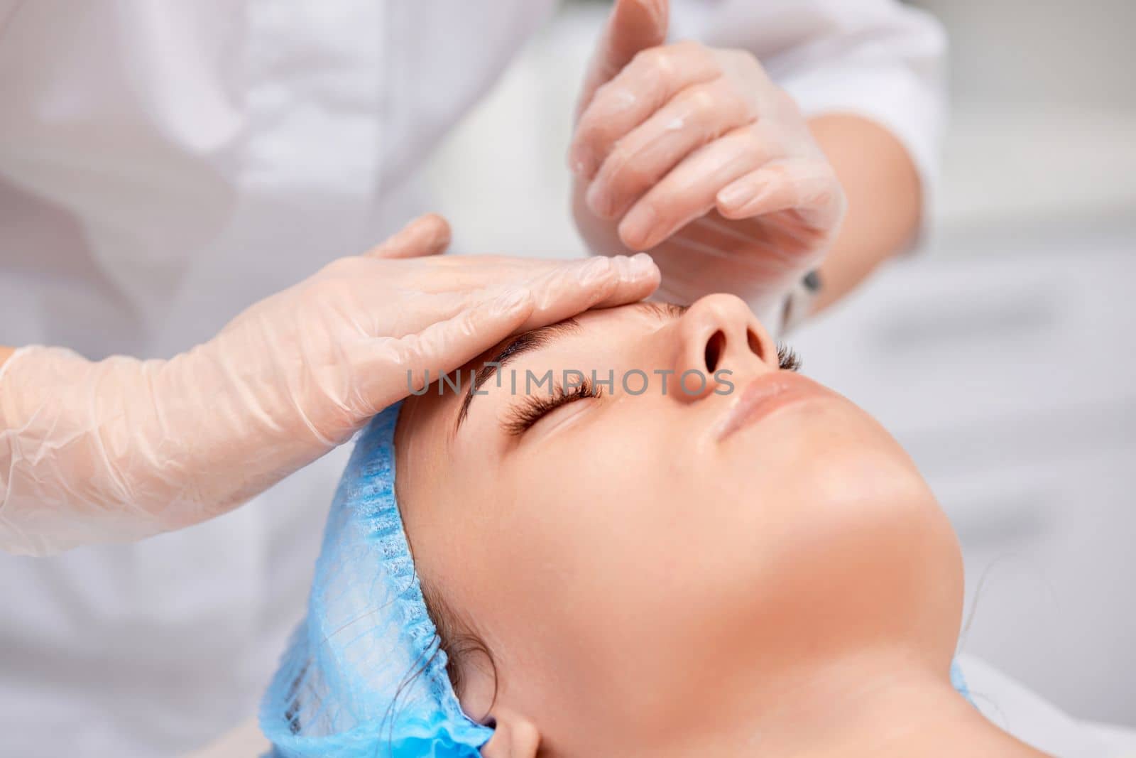 young beautiful woman receiving anti-stress facial massage at spa salon