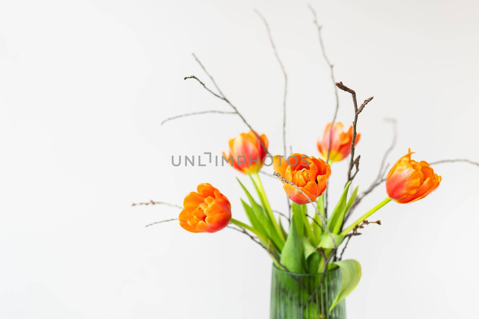 A very beautiful spring bouquet in a green vase stands on a table on a linen tablecloth, orange peony tulips. Mother's Day, March 8, Valentine's Day. Place for an inscription. by sfinks
