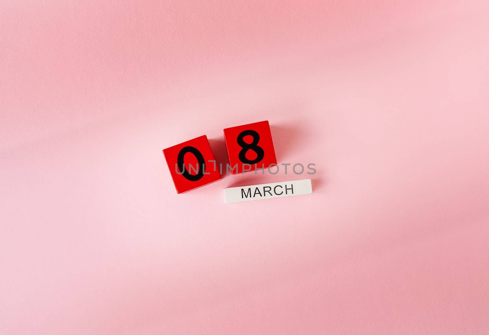 Wooden cubes with the inscription March 8 on a pink background, the inscription of a happy women's day. Ready card for the holiday, Women's Day