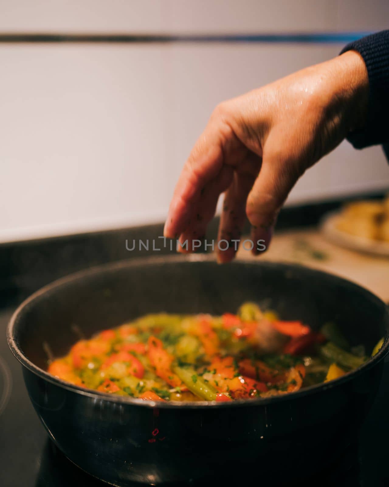 woman housewife hand opened adding ingredients in a frying pan.