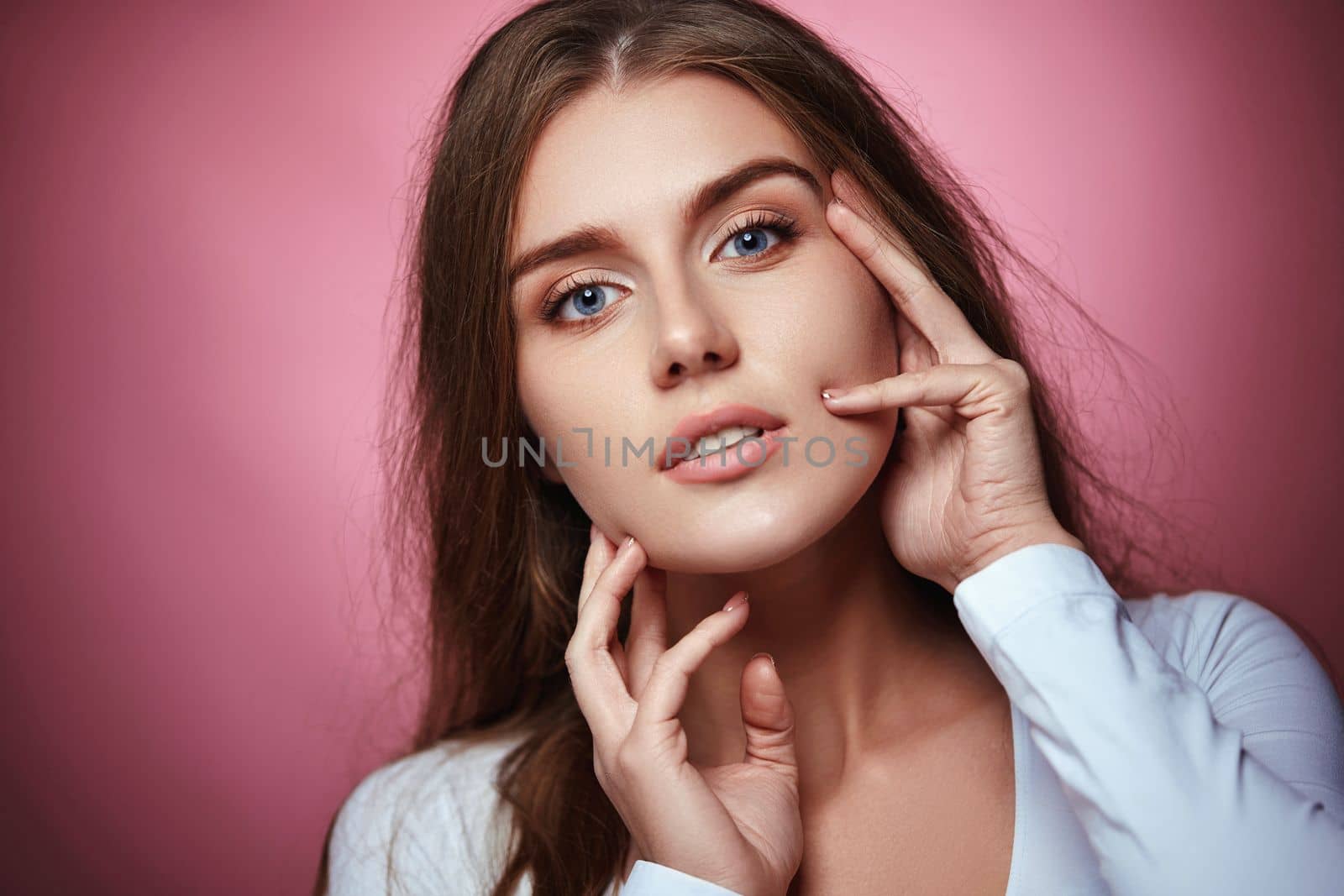 beautiful woman with healthy curly hair on pink background