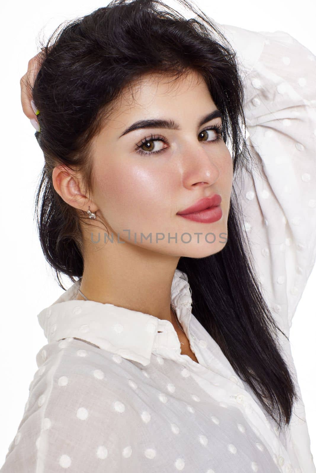 beautiful brunette young woman in a white blouse smiling on a white background