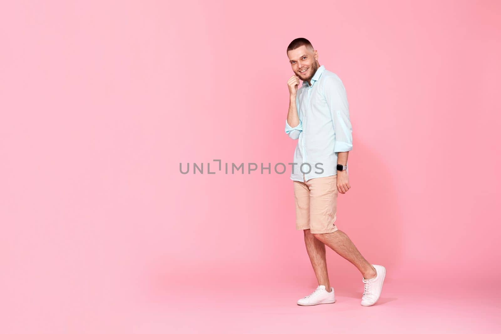 young caucasian smiling bearded man wearing casual shirt isolated on pink background. Full length