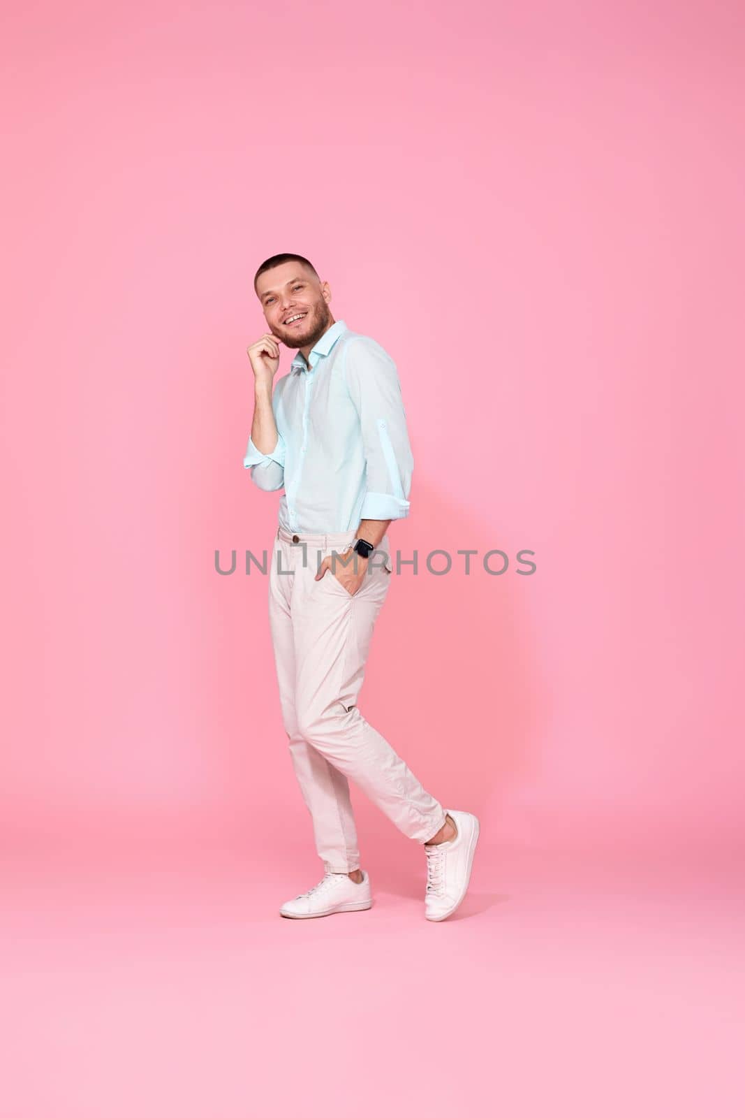 young caucasian smiling bearded man wearing casual shirt isolated on pink background. Full length