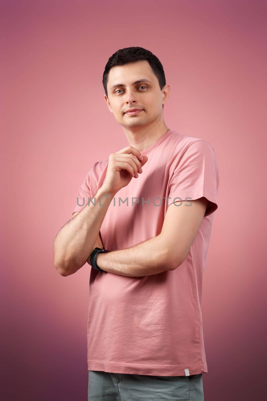handsome man in t-shirt looking at the camera on pink background