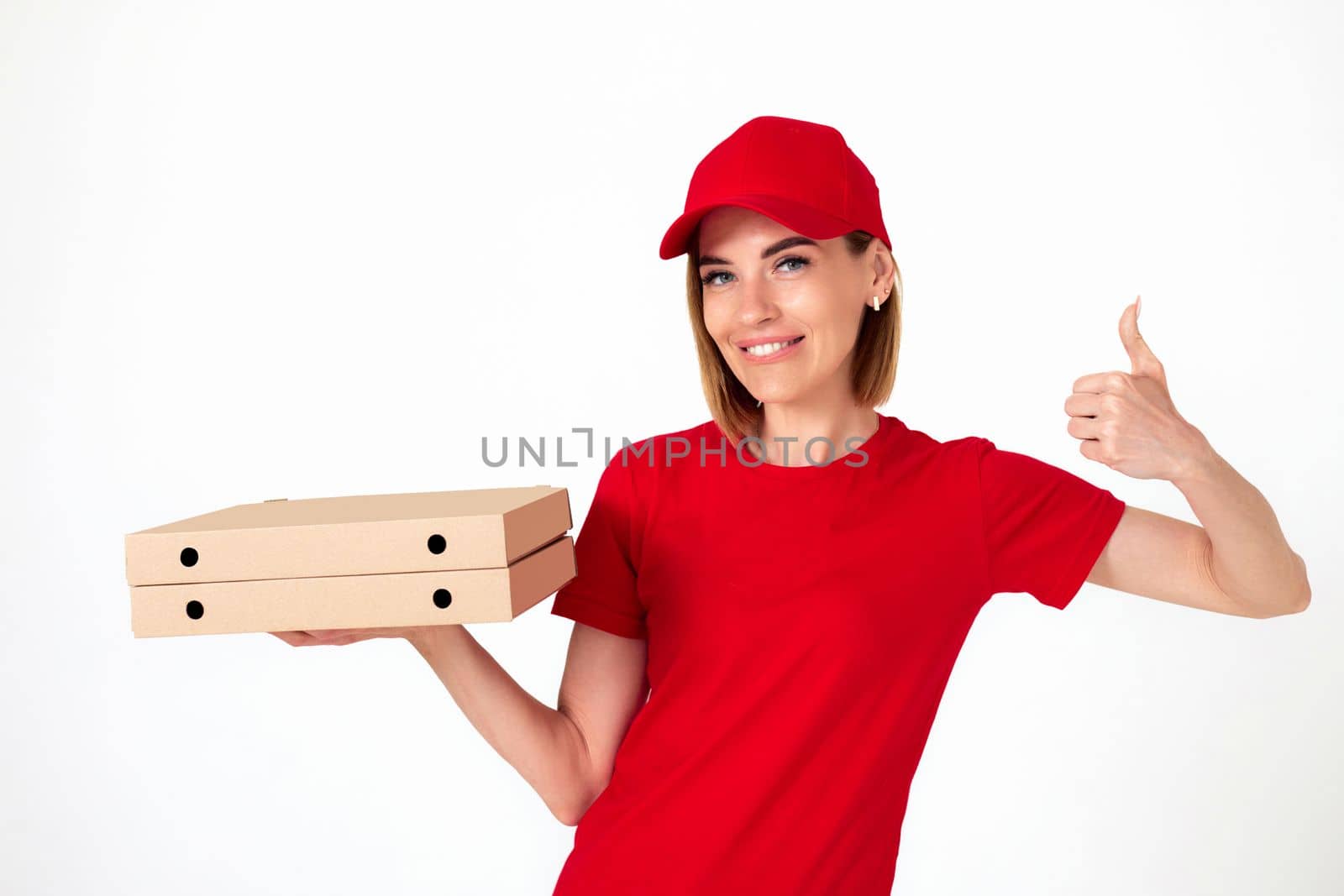friendly pizza delivery woman in uniform with pizza boxes showing thumbs up on white background
