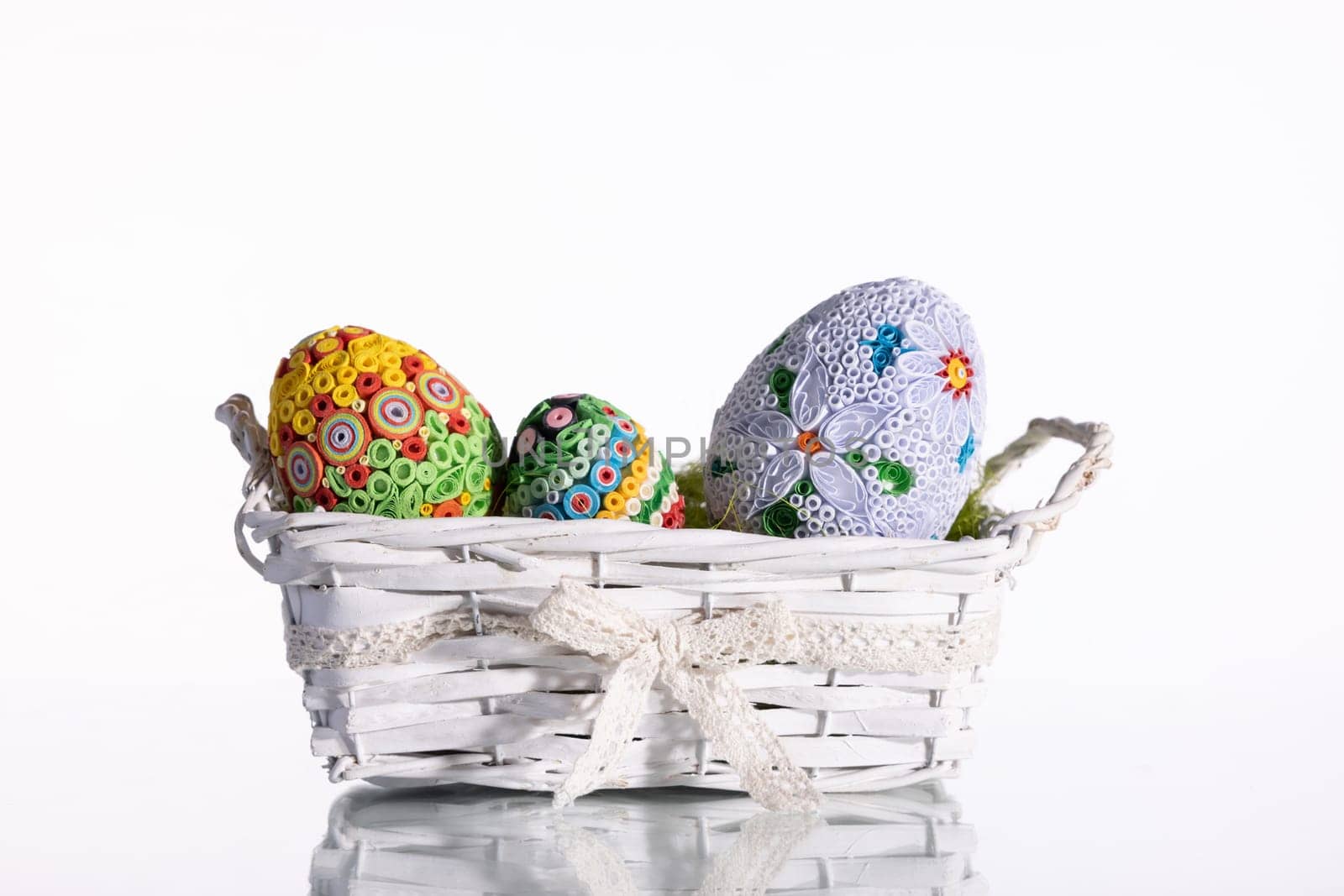 Isolated behind the background a woven basket with three Easter eggs. Important symbols of the world in the Christian religion.