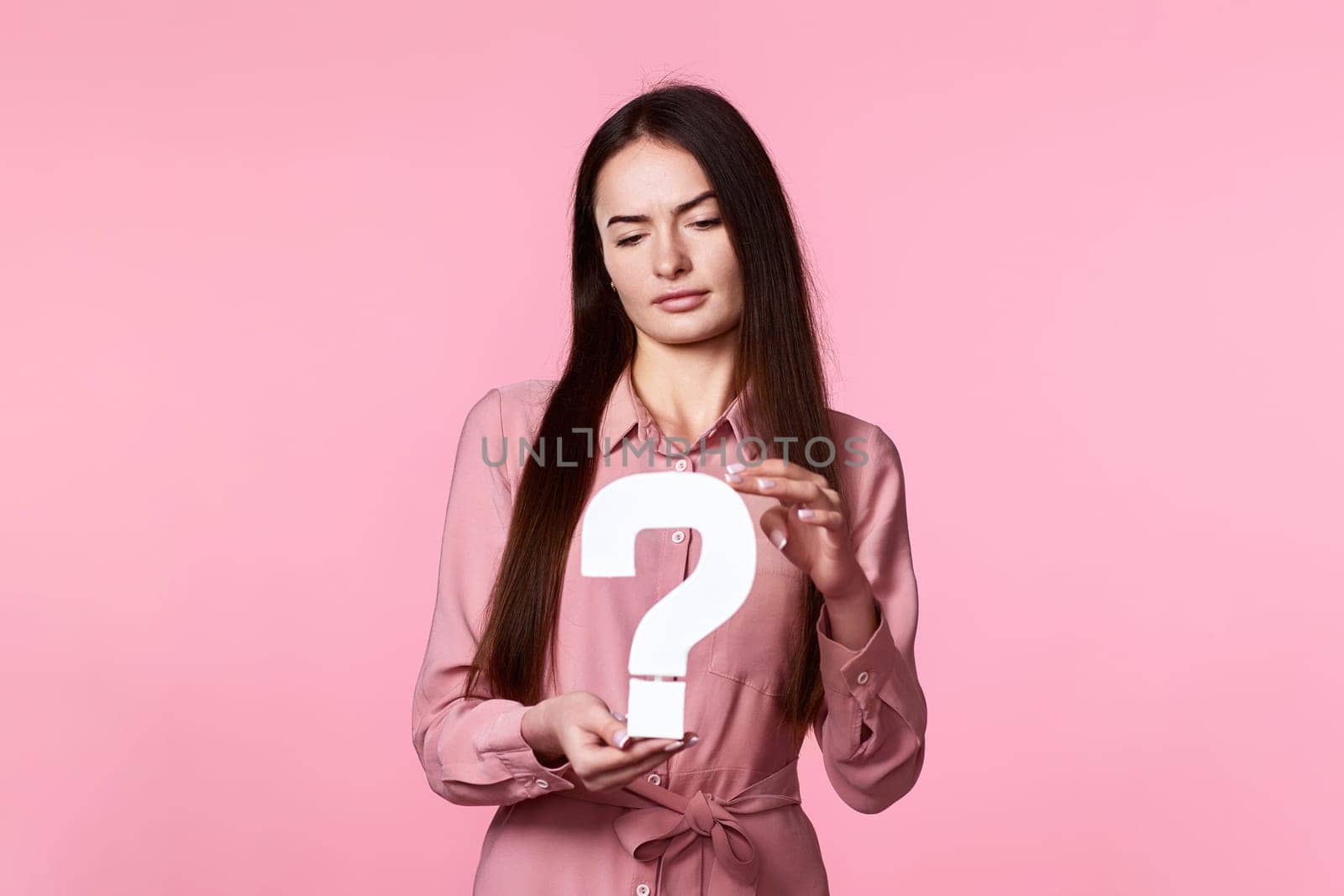 beautiful caucasian woman with question mark on pink background