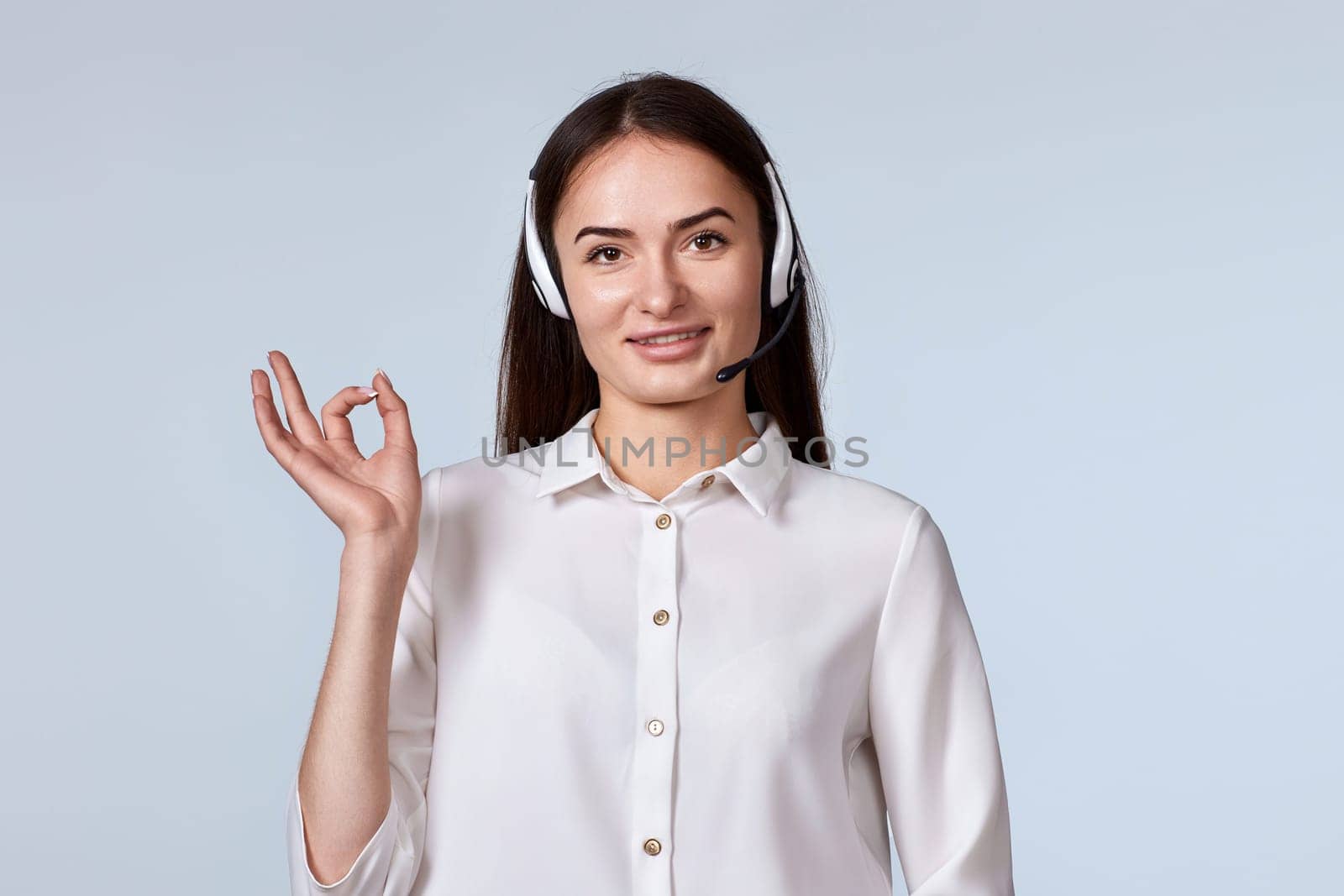 woman in headset is consulting clients online. call centre operator showing Ok gesture