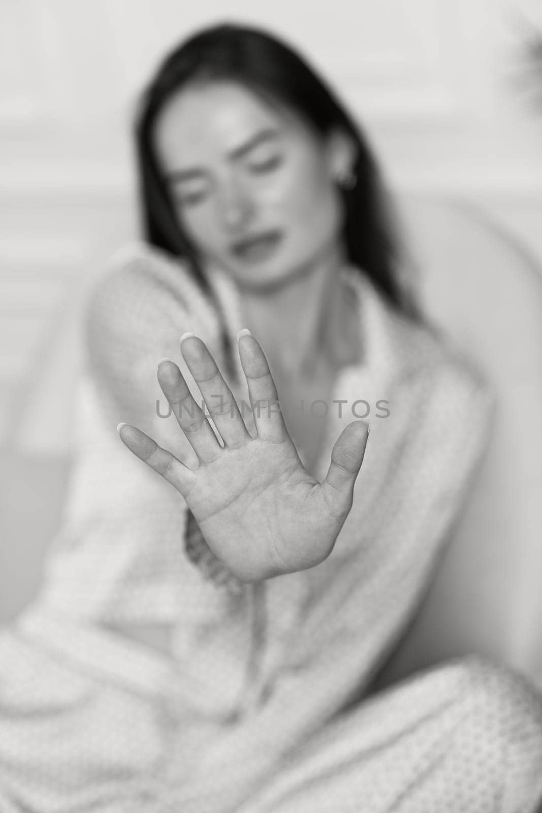 brunette woman in pajamas showing stop gesture. black and white