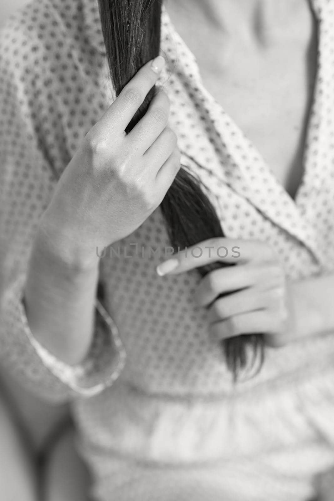 female hands hold long smooth hair. black and white