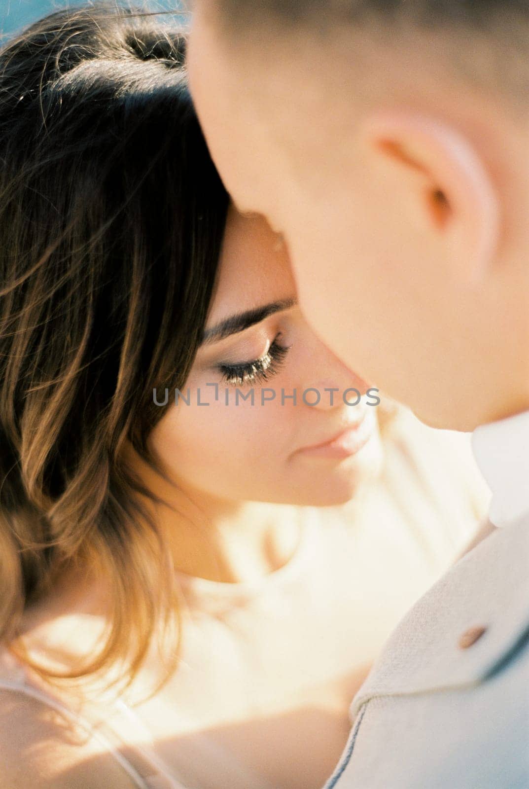 Groom bowed his face to the face of bride. Portrait. High quality photo