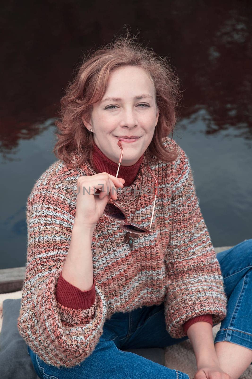 portrait of a young beautiful girl with developing hair in an autumn sweater. High quality photo