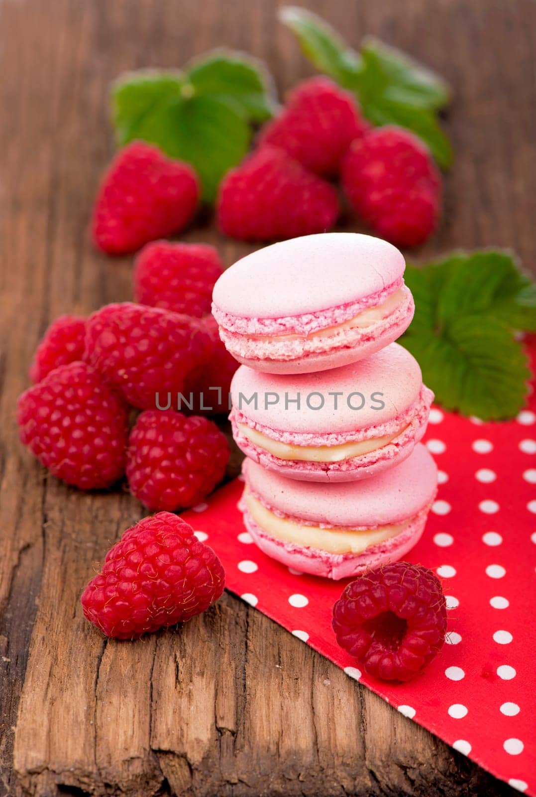 Pink raspberry macaron cookies on dark wooden boards