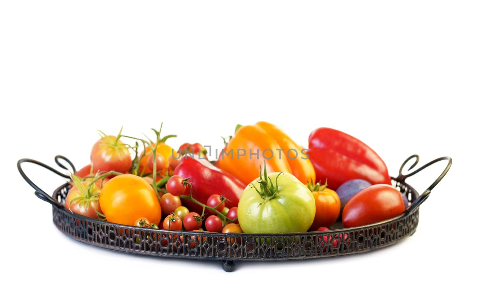 Colorful tomatoes of different sizes and kinds in dark wooden tray over light textile and rustic wooden background, top view, horizontal composition by aprilphoto