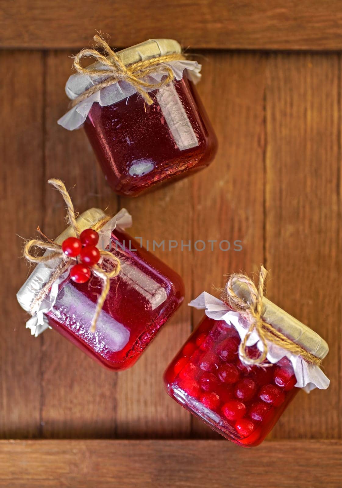 Viburnum fruit jam in a glass jar on a wooden table