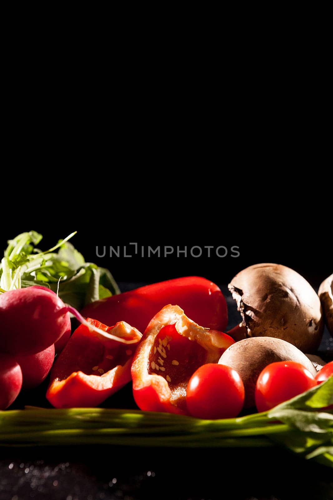 Artistic image of different type of healthy organic vegetables on dark background in studio photo