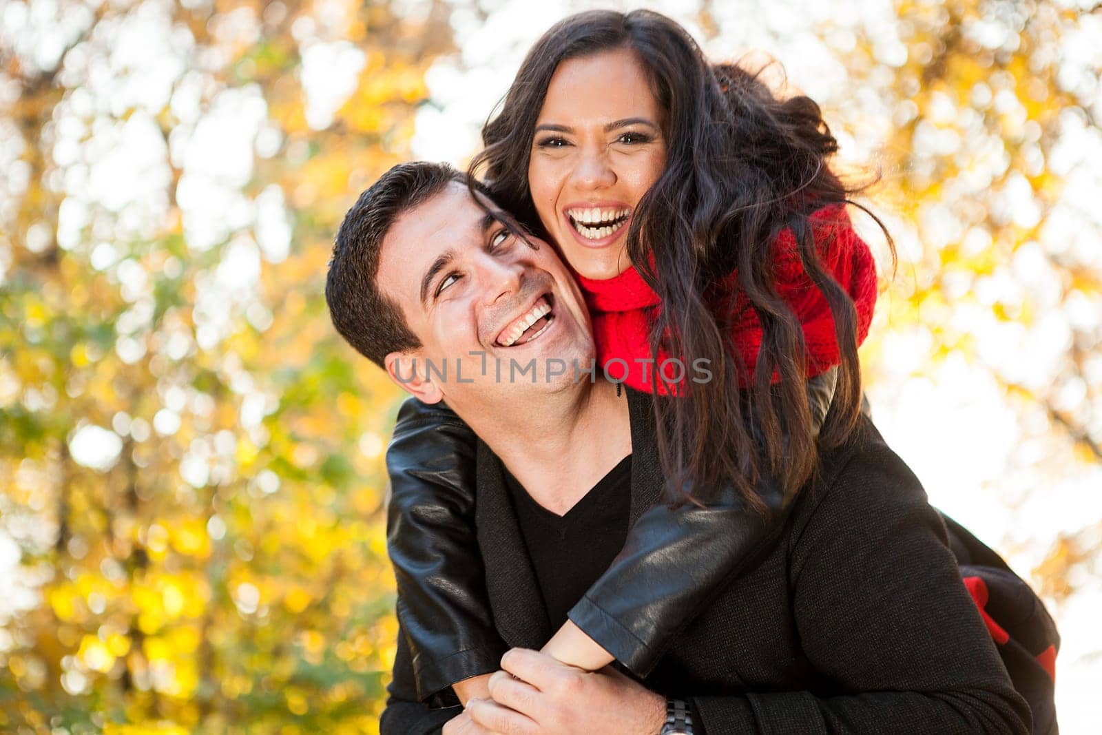 Amazing funny young couple in autumn park having fun