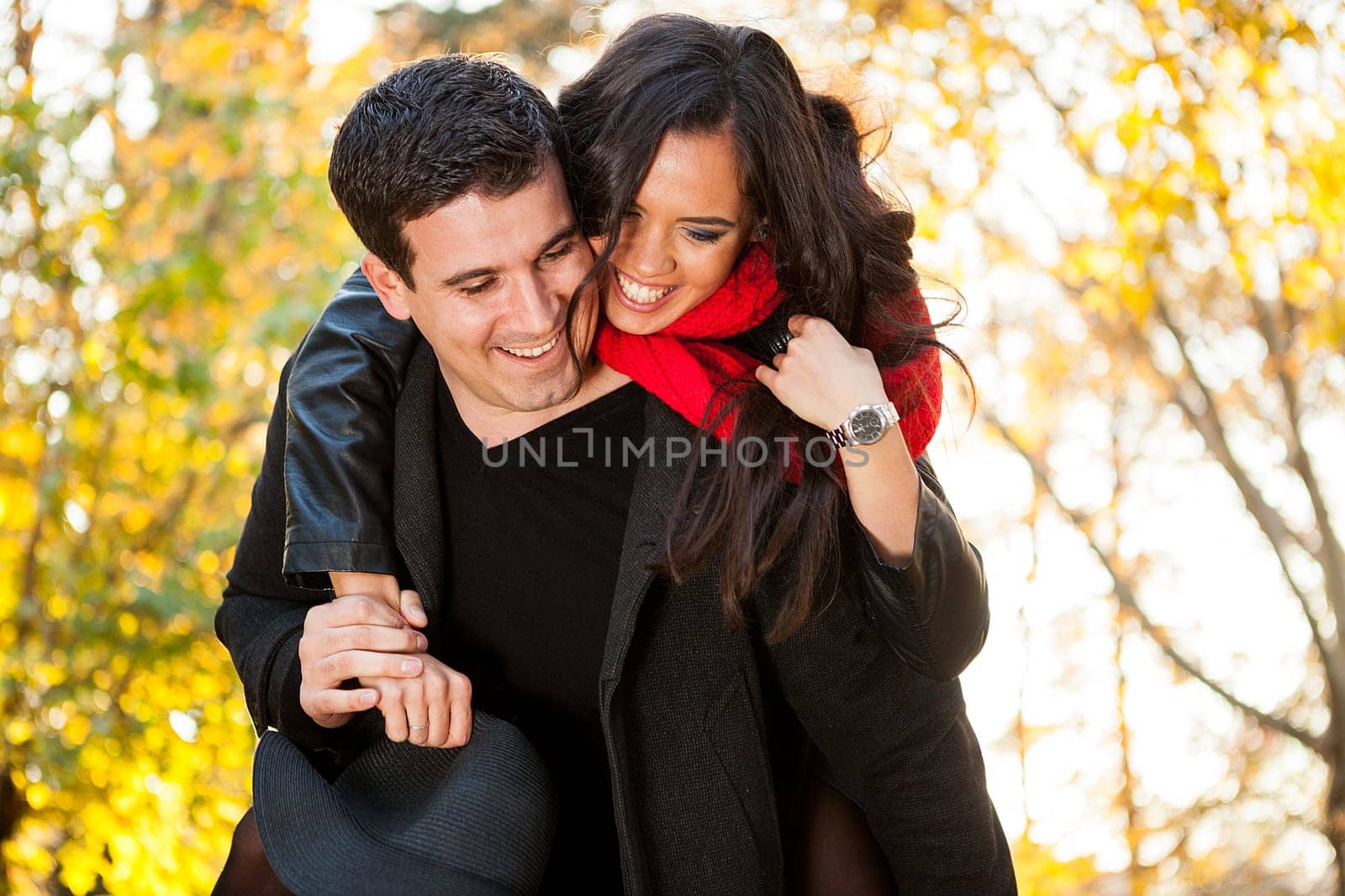 Amazing funny young couple in autumn park having fun