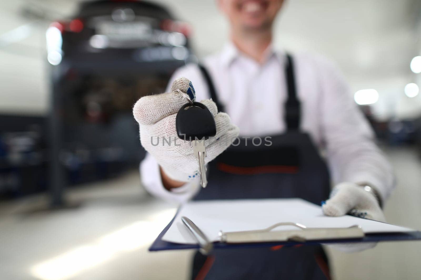 Car repair and maintenance services. Master holds key and documents for car in auto repair shop concept