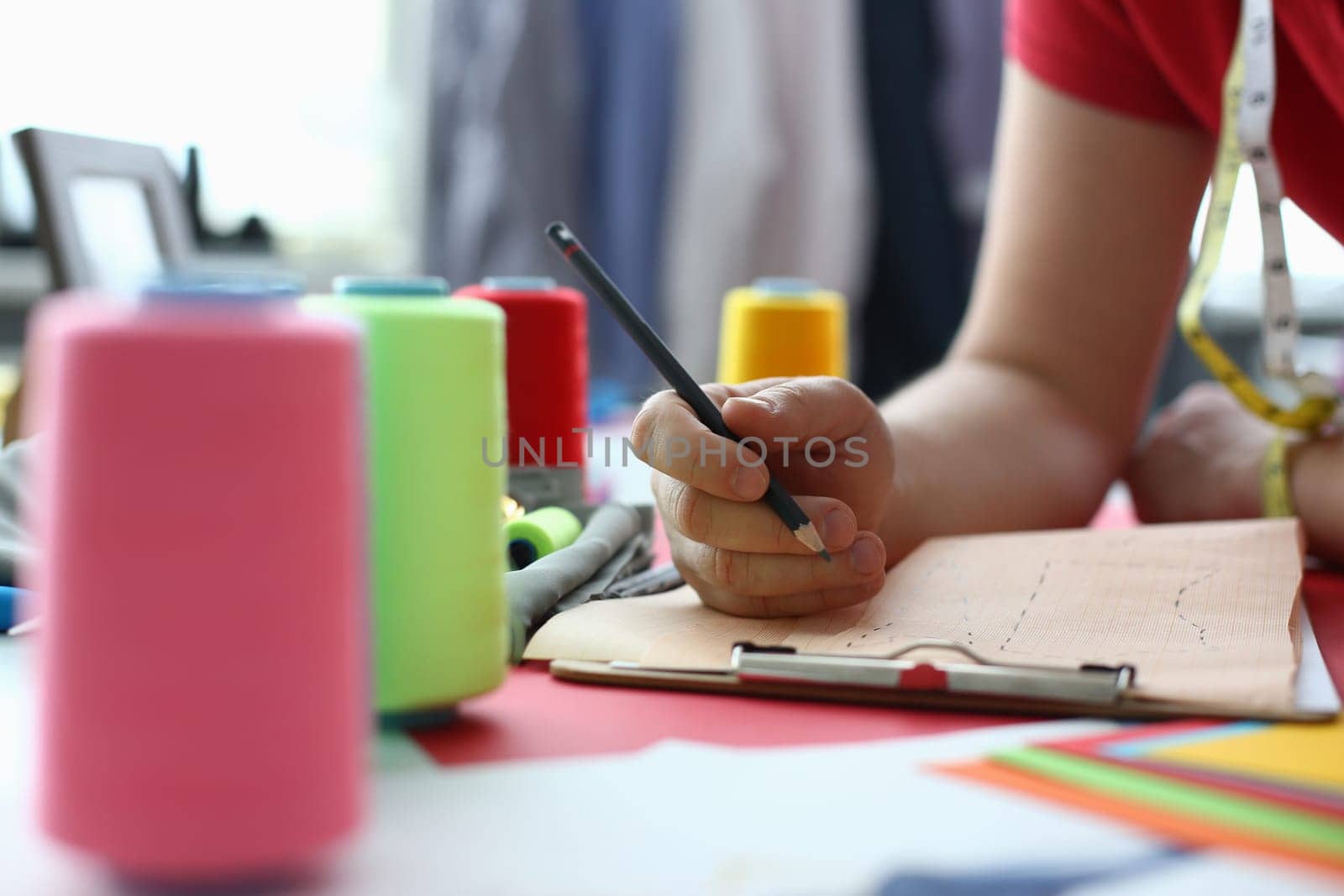 Female fashion designer stylist working with sketches in studio closeup. Creative drawing sketch clothes collection