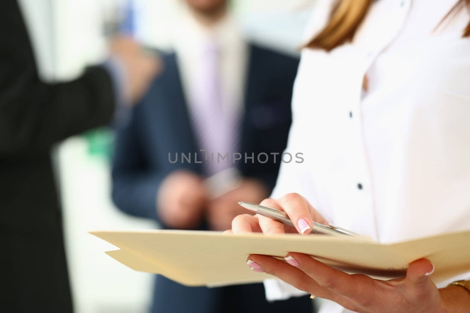 Women hands holding pen and documents in background business people. Business agreements and joint partnerships
