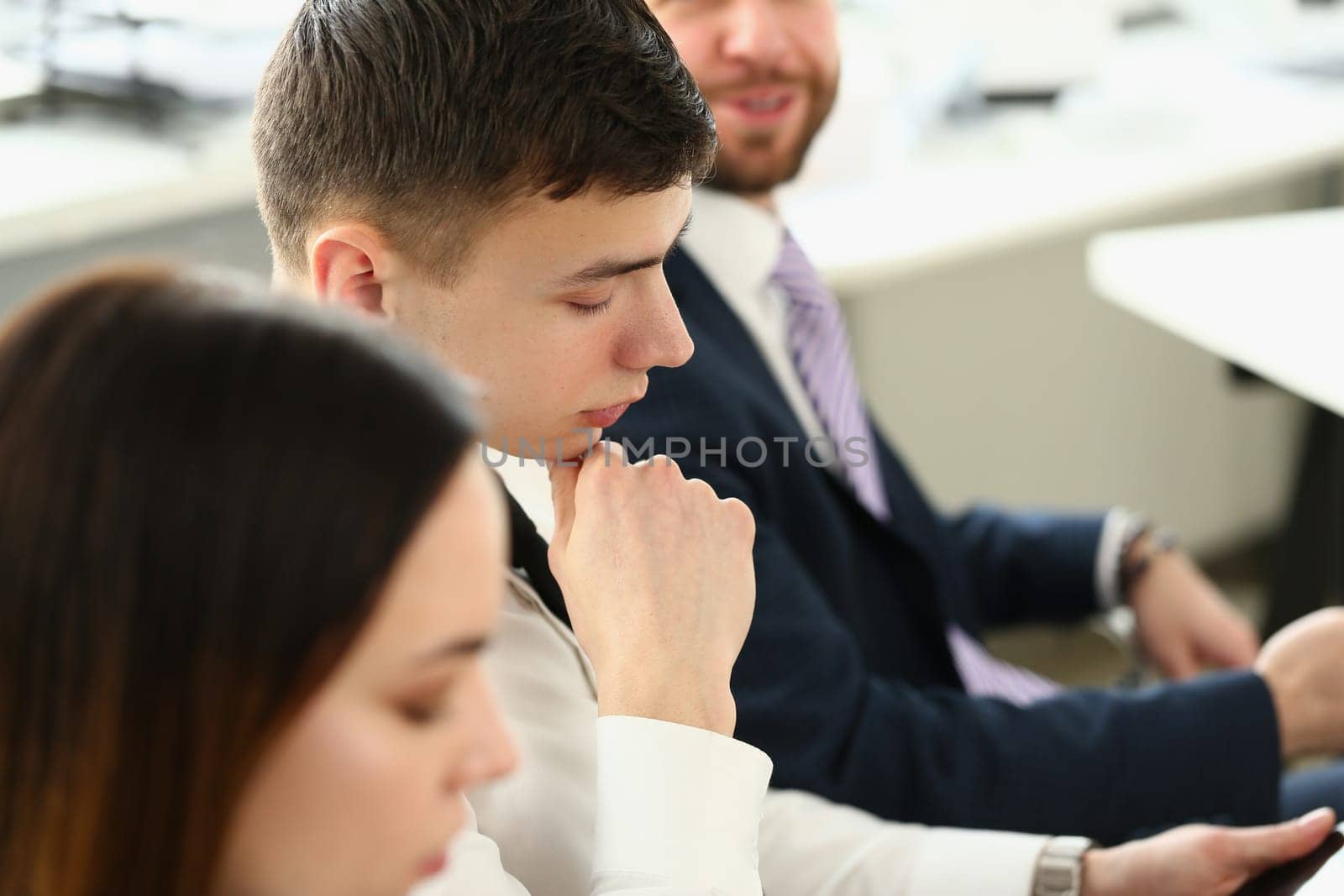 Portrait of confident people seriously looking at business papers during work meeting by kuprevich
