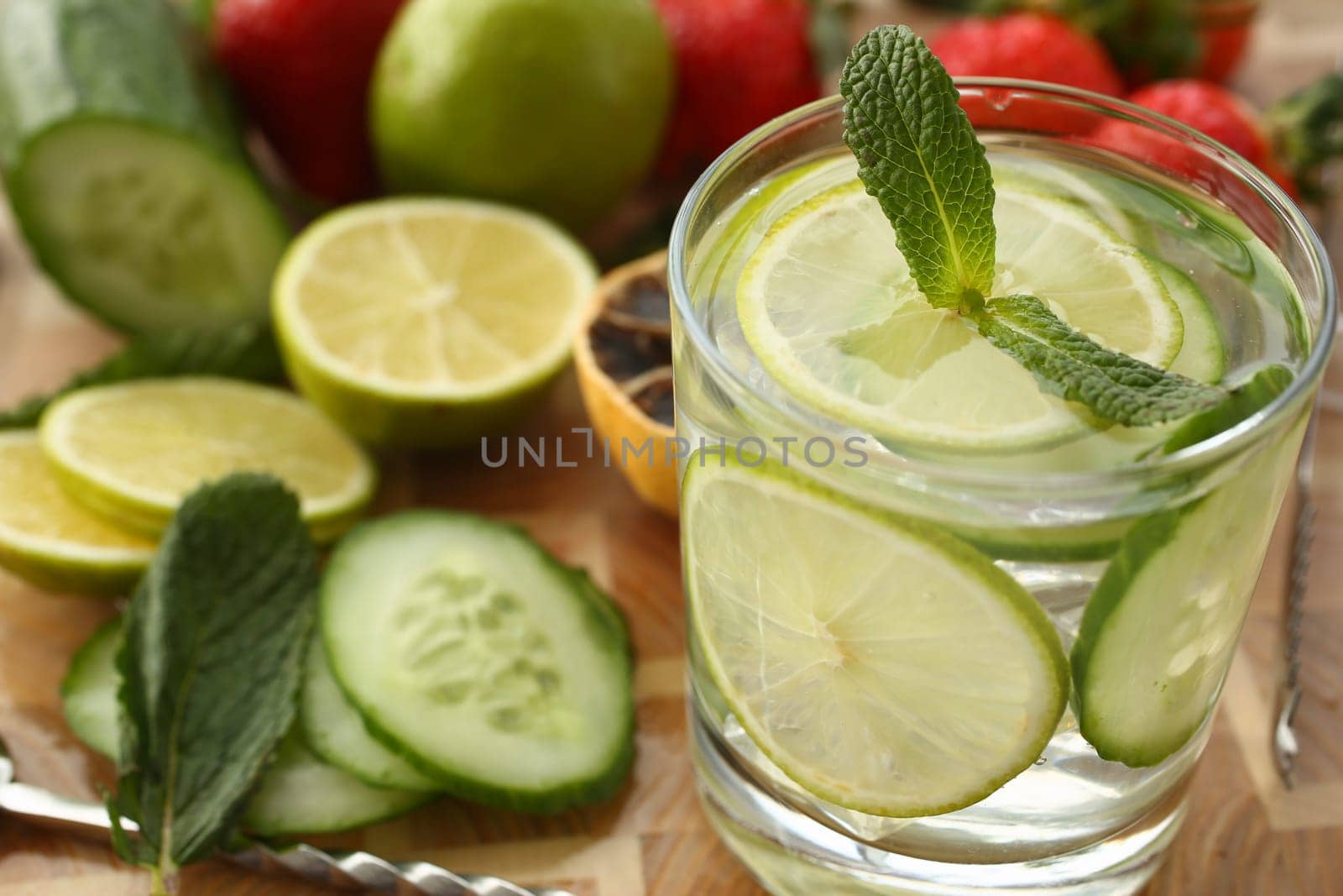 Lime with cucumber punch with mint and ice in glass. Homemade chilled vitamin smoothie closeup