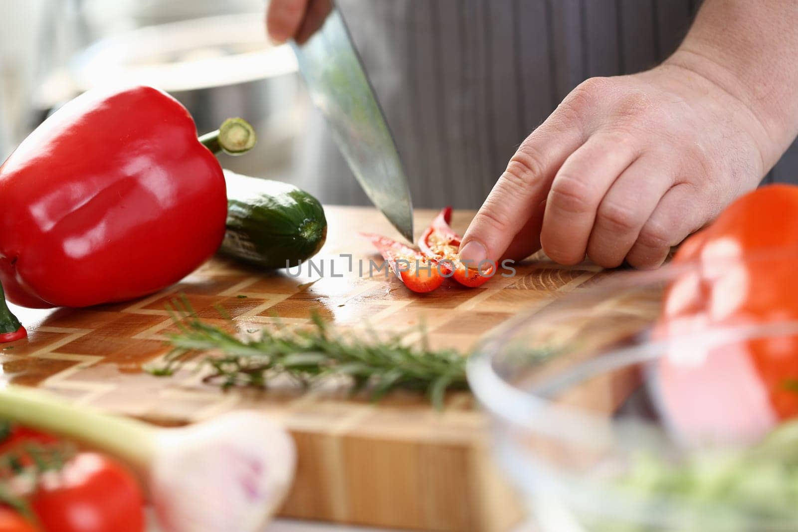 Chef cuts chili peppers on board closeup. Cooking vegetables and vegan food with spices concept