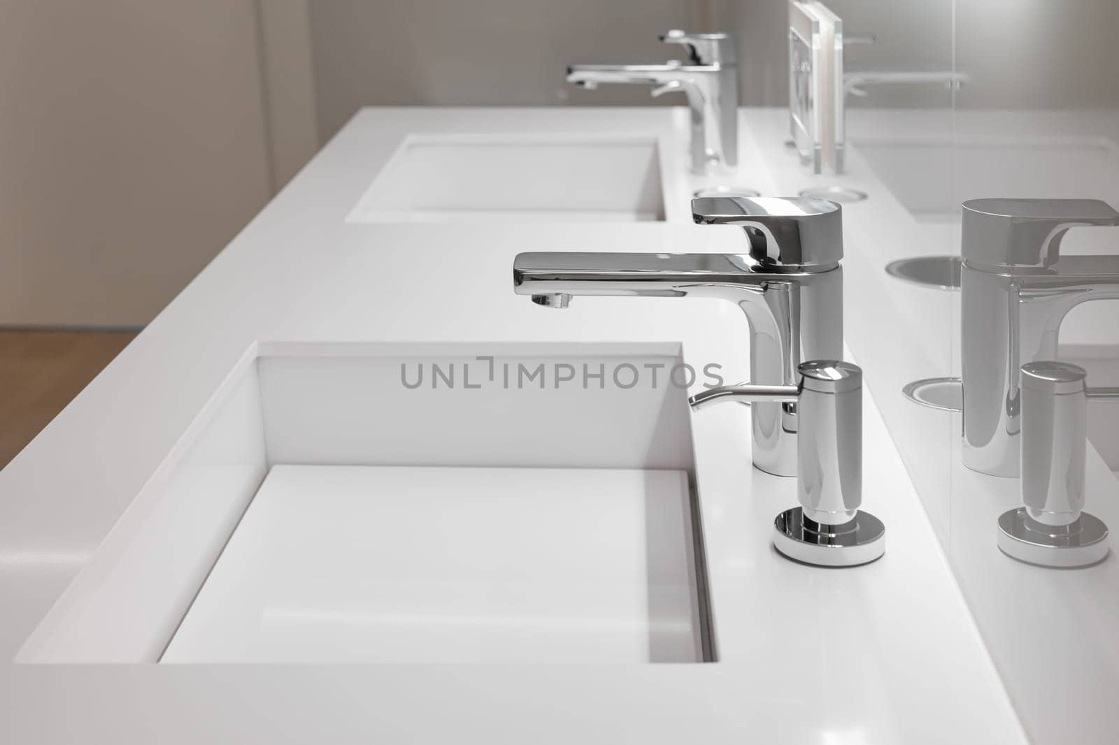 Side view of double white sink with large and small taps for filtering running water for drinking. Concept of modern filtration system and design by apavlin