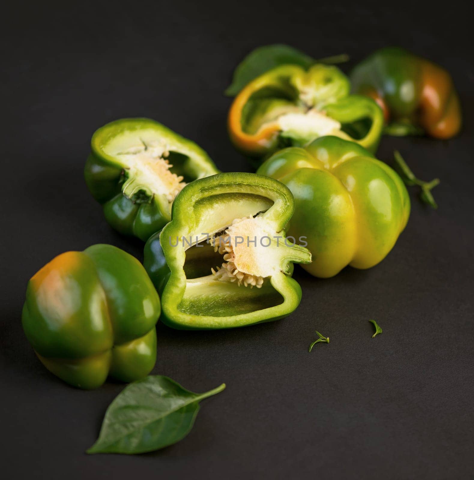 Fresh sweet and sliced pepper on black background by aprilphoto