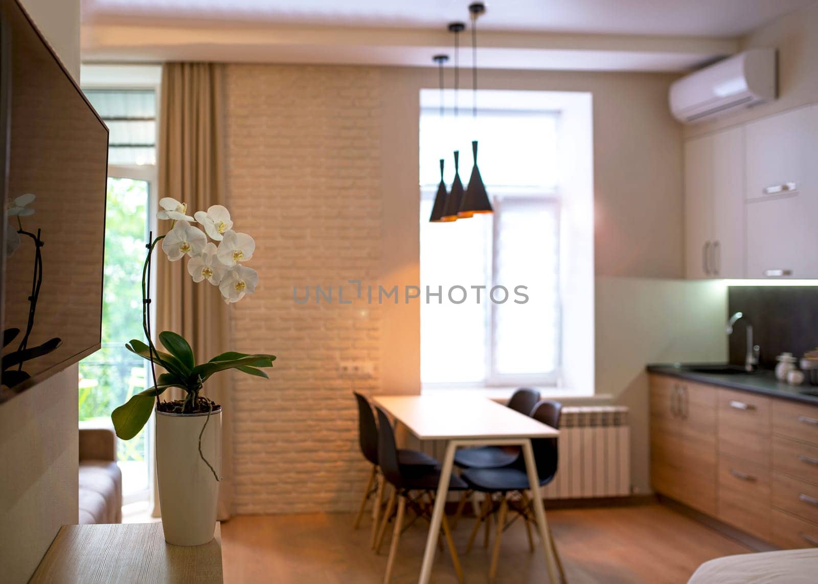 Open plan living room and kitchen interior with white cabinets, table and chairs by aprilphoto