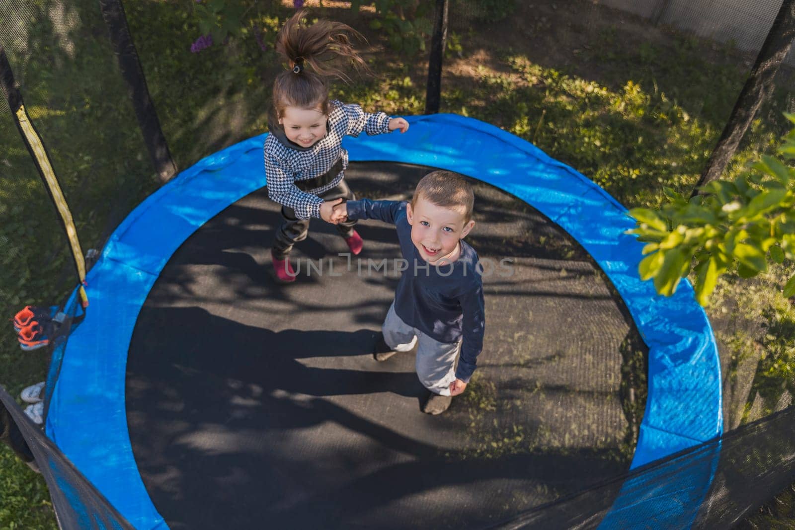 children jumping on a trampoline top view