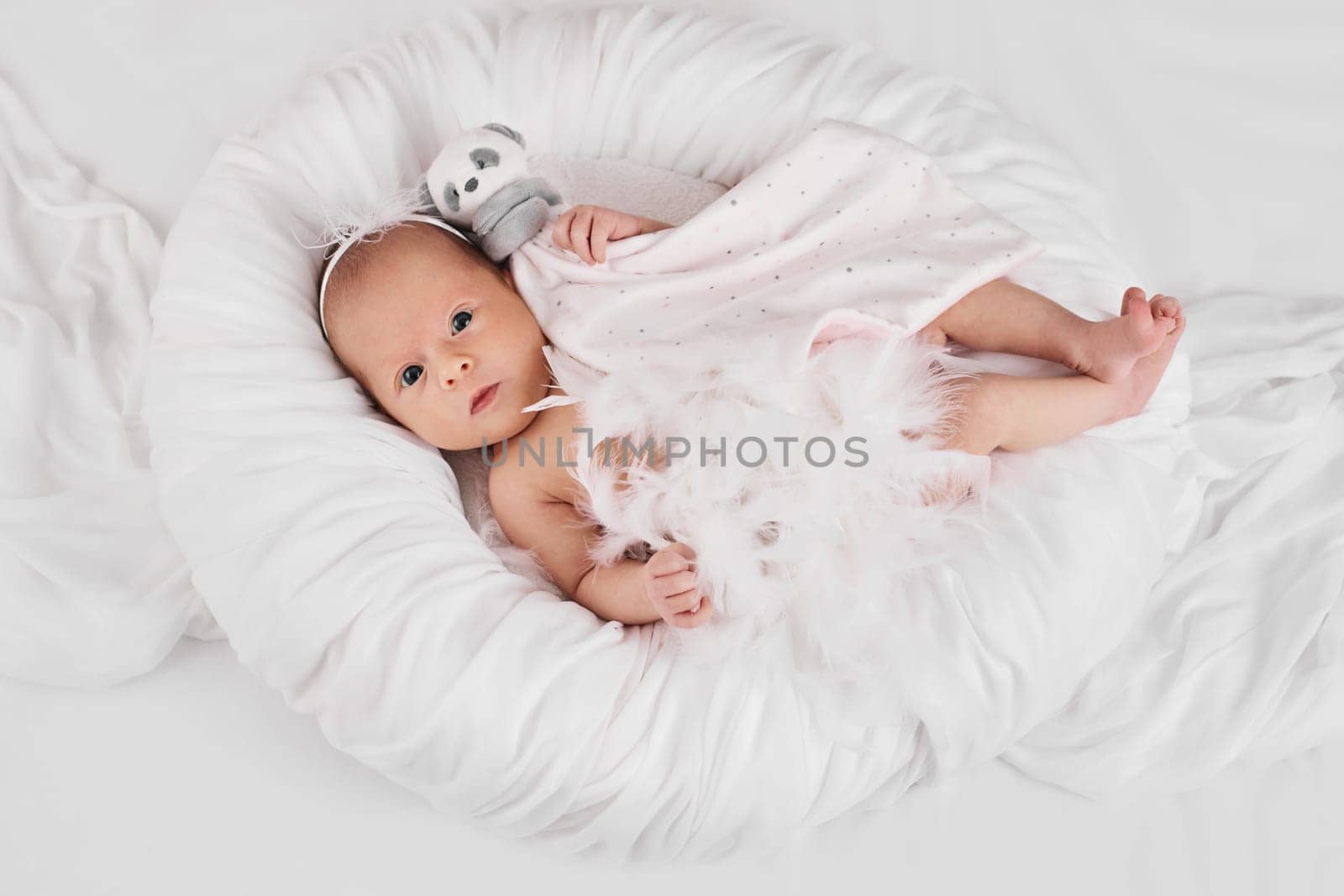 sweet newborn baby sleeping with teddy bear toy on white background