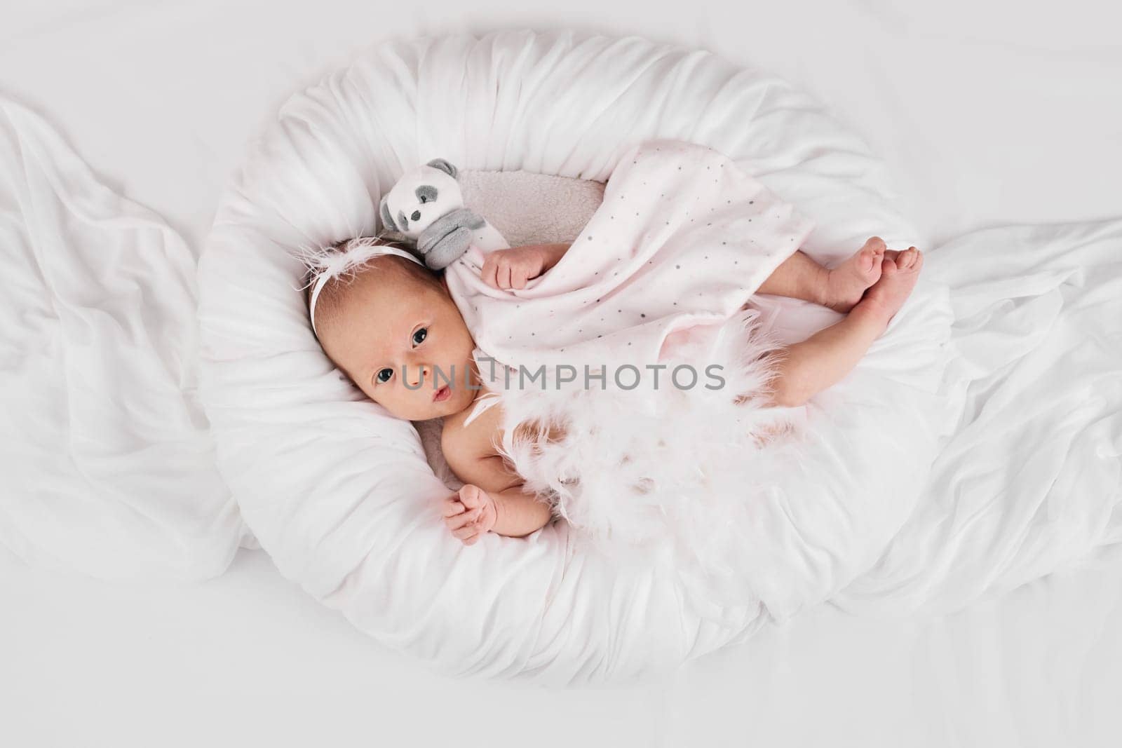 sweet newborn baby sleeping with teddy bear toy on white background