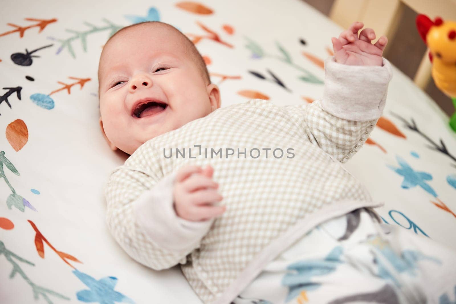 happy newborn baby in crib at home by erstudio