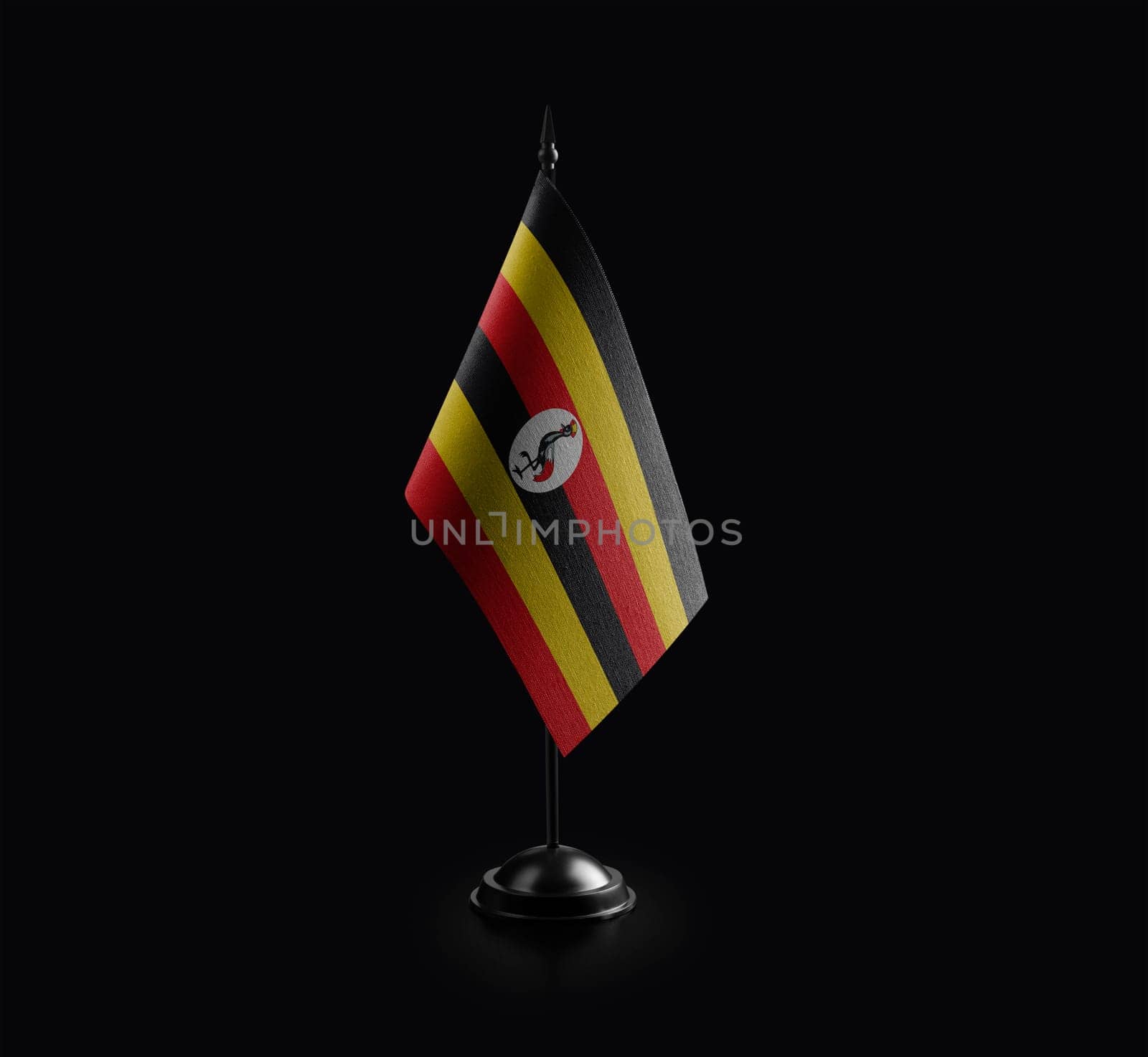 Small national flag of the Uganda on a black background.