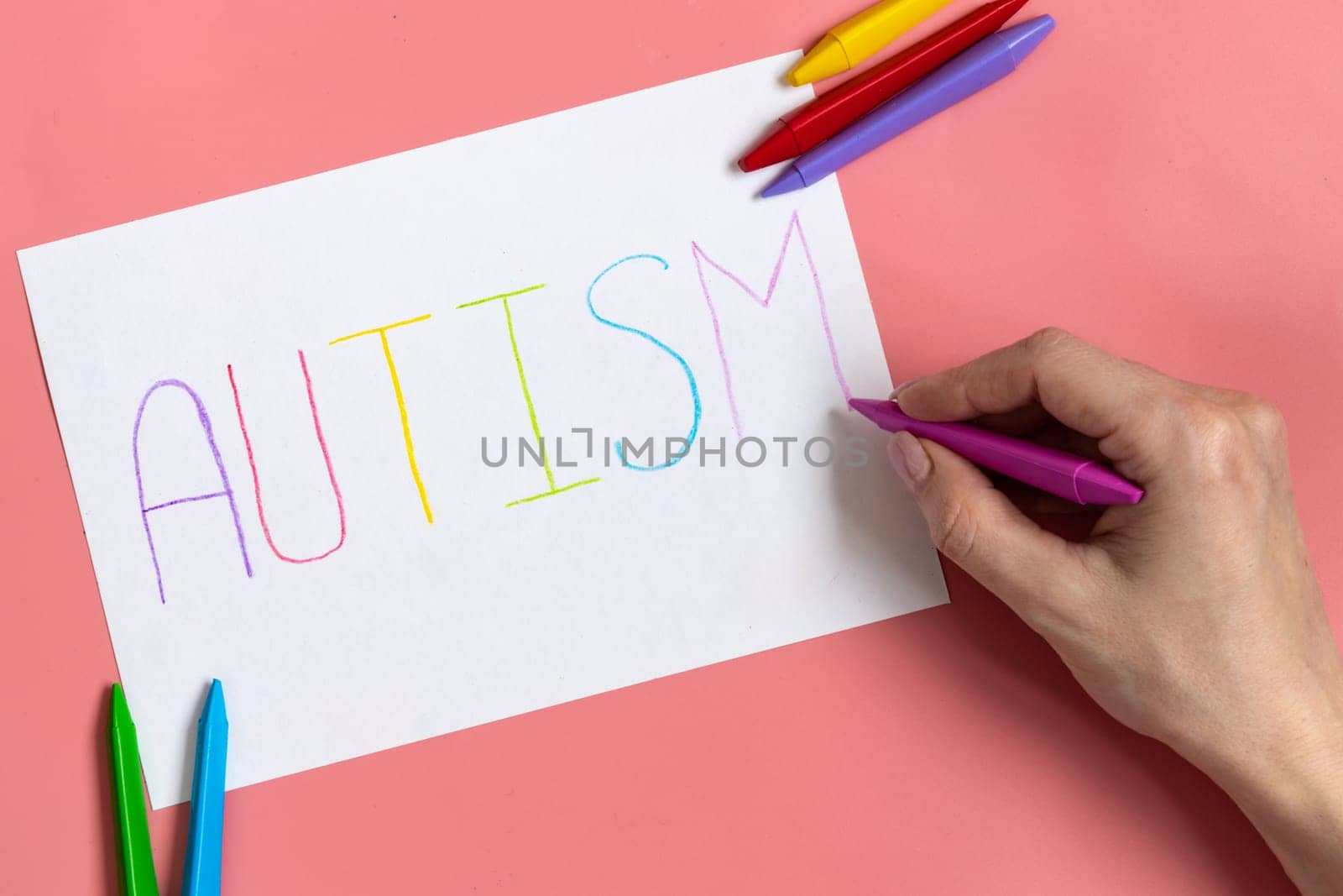 Text word autism on paper sheet written by colorful letter, on blue background. by Ri6ka