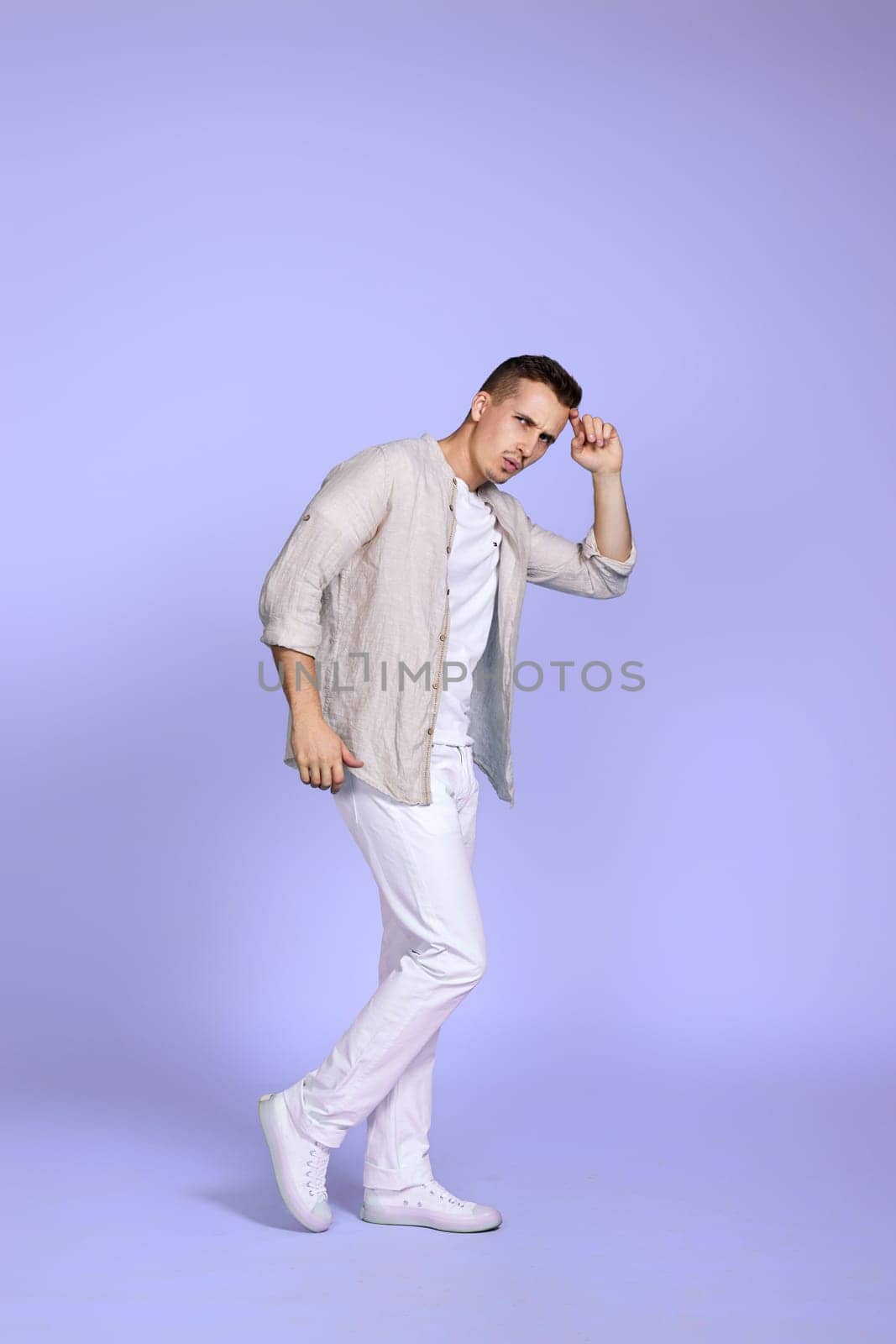 optimistic caucasian man dancing on pastel violet background. vacation summer. Full body