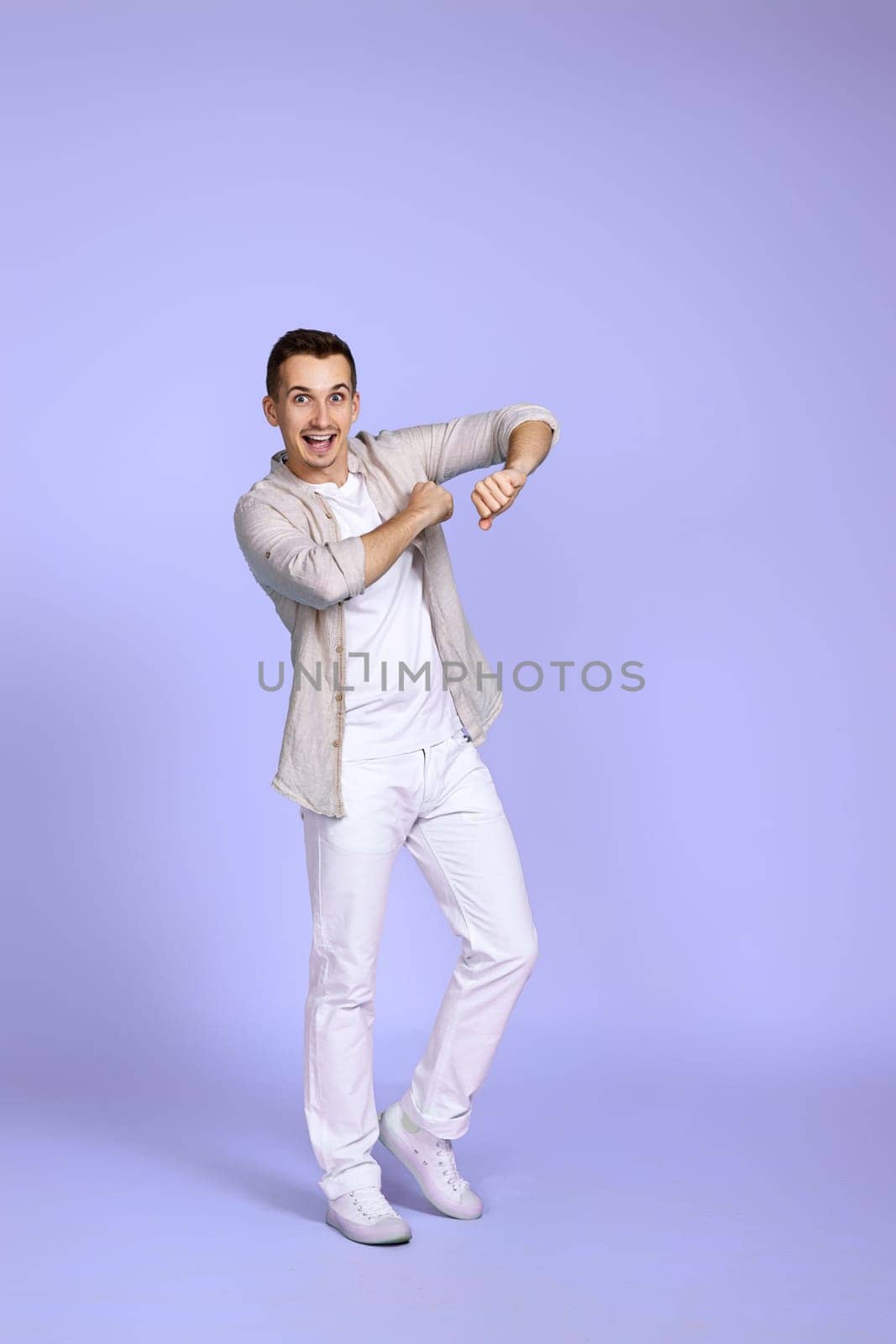 optimistic caucasian young man dancing on pastel violet background. vacation summer. Full body