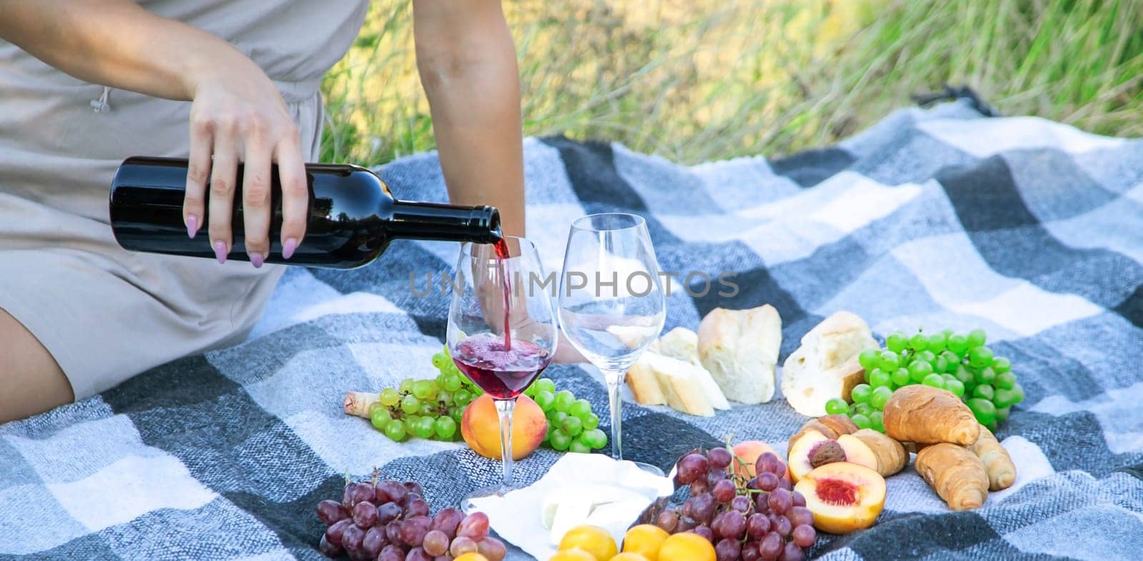 picnic in nature, girl pouring wine, couple in love. nature. selective focus